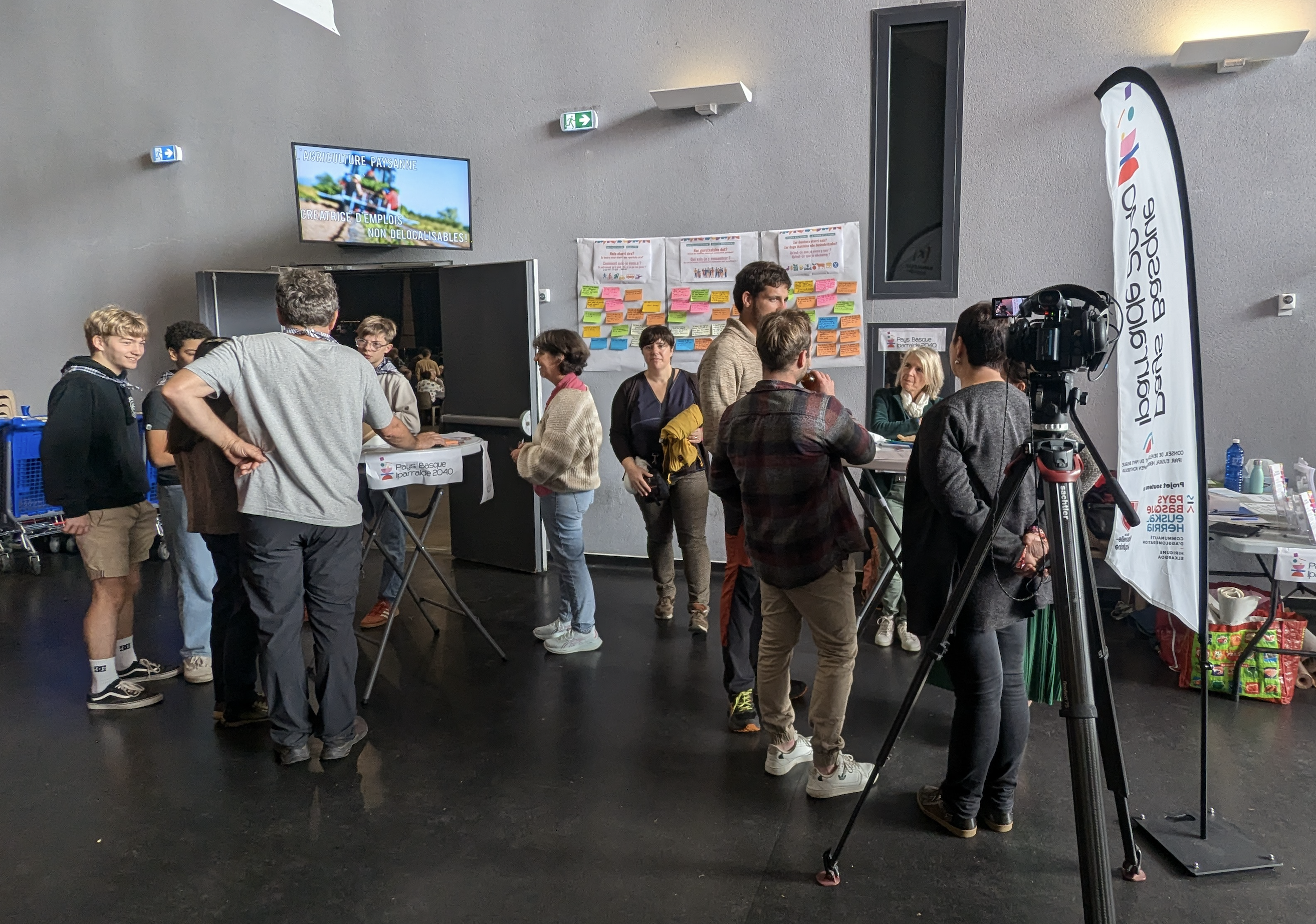 Une quizaine de personnes sur le stand IPARRALDE 2040 à Lurrama, avec au premier plan une caméra de télévision